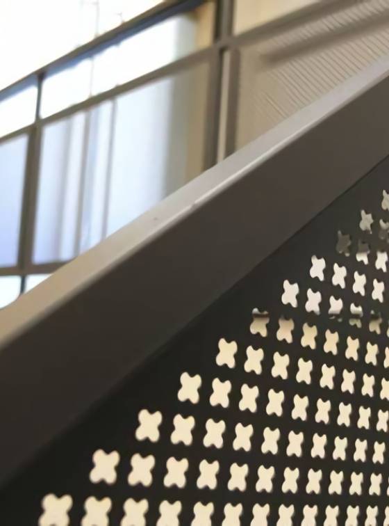 The handrail is made of clover perforated metal.