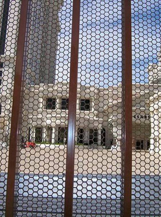 The community gate is made of hexagonal perforated metal.