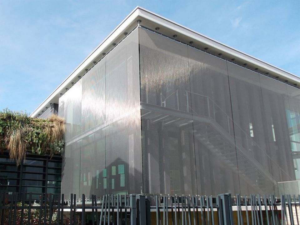 Metal architectural mesh surrounds the whole building