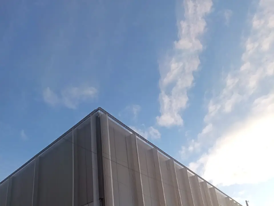 Metal architectural mesh surrounds the whole building