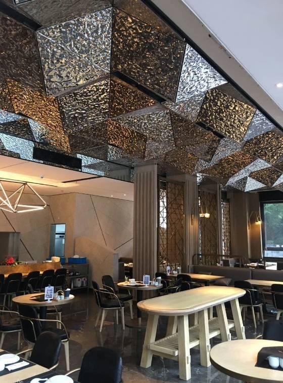 The restaurant ceiling is decorated with water ripple stainless steel sheets.
